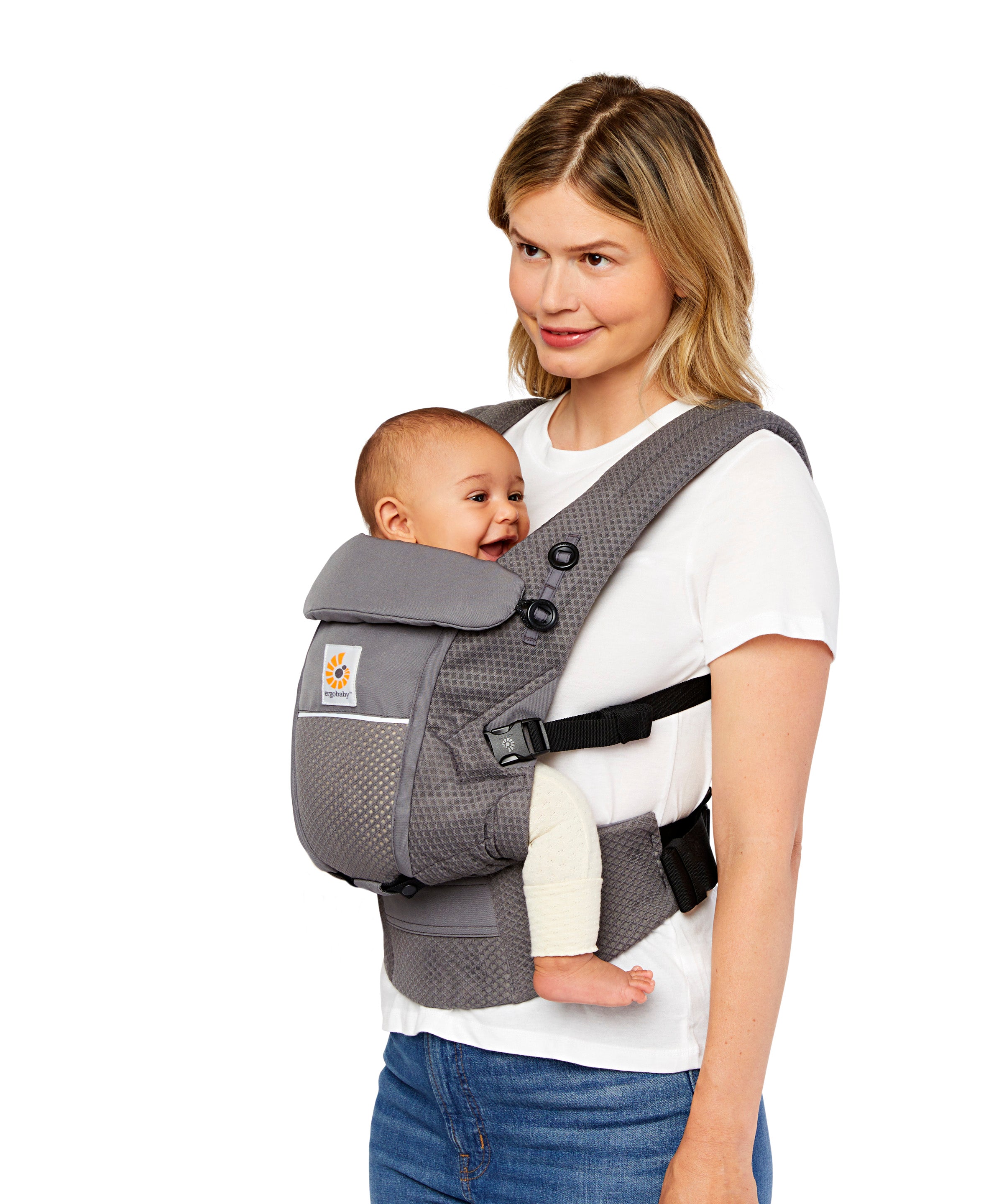 Woman with blonde hair and a white t-shirt wearing her baby in the Ergobaby Adapt  SoftFlex™ Mesh Baby Carrier in Graphite Grey. Side  view, white background. 