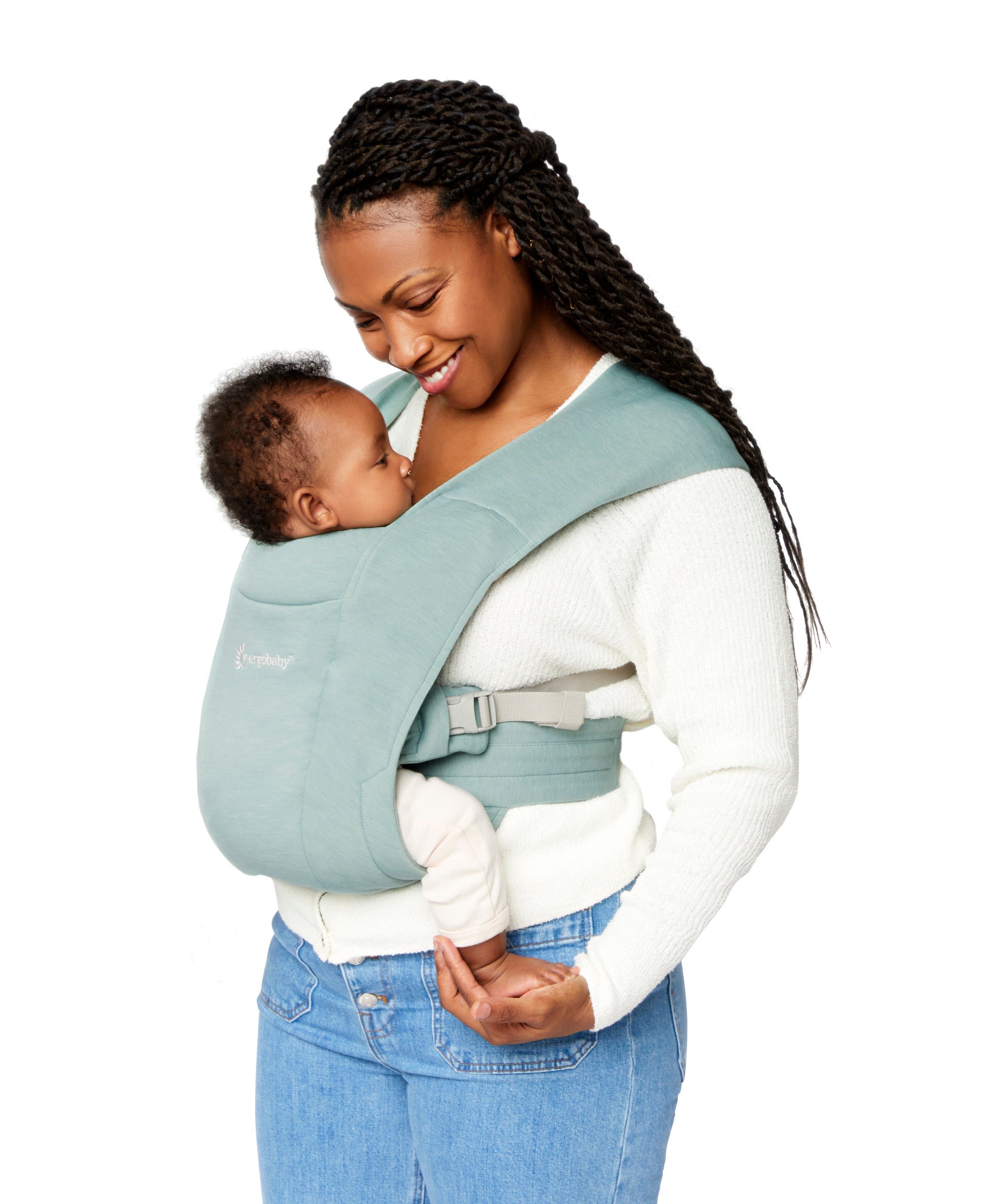 Woman wearing a white top and her baby on her front facing inwards in the Ergobaby Embrace Soft Knit Newborn Baby Carrier in Jade. Side view white background.