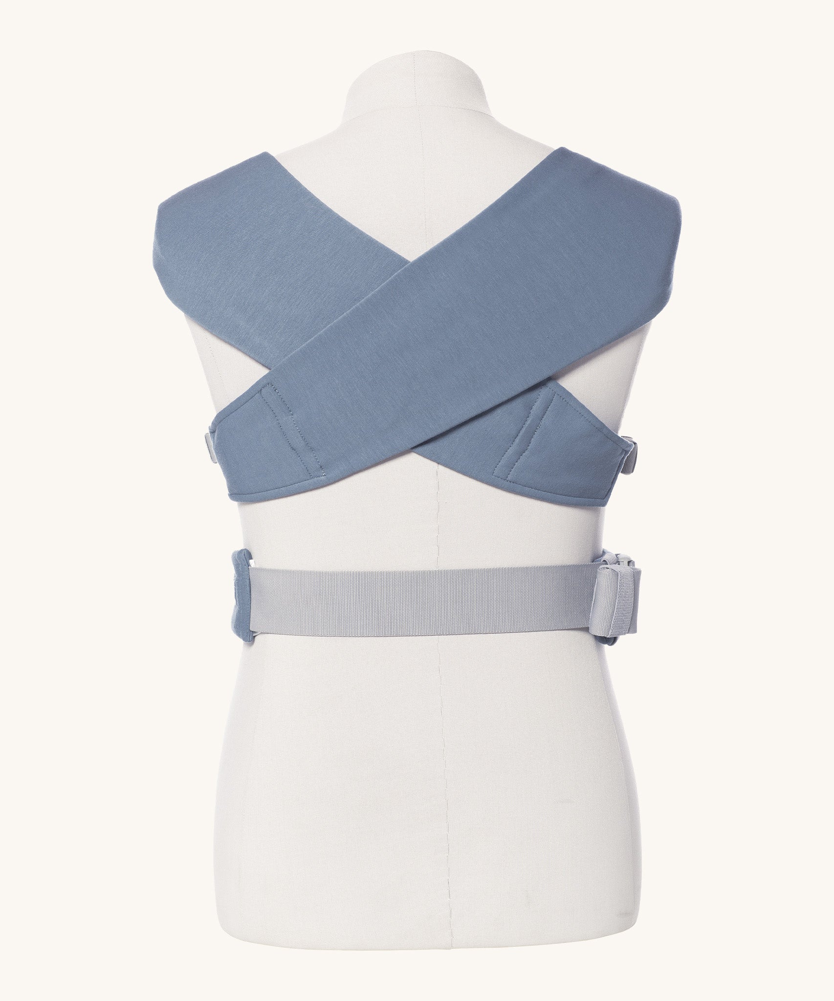 Ergobaby Embrace Soft Knit Newborn Baby Carrier in Oxford Blue. Back view showing cross over straps on a mannequin.