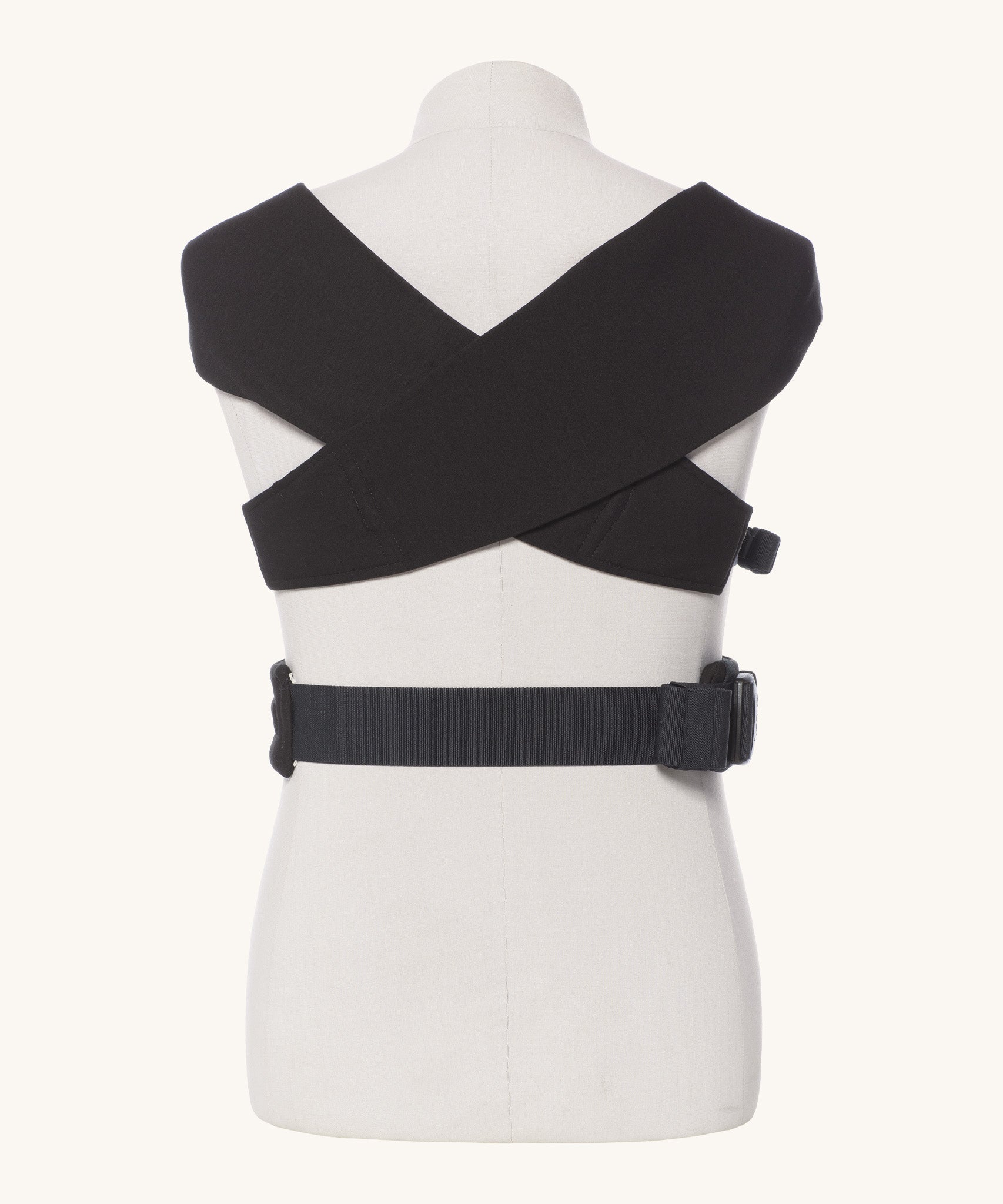 Ergobaby Embrace Soft Knit Newborn Baby Carrier in Pure Black. Back view showing the cross over straps on a mannequin.