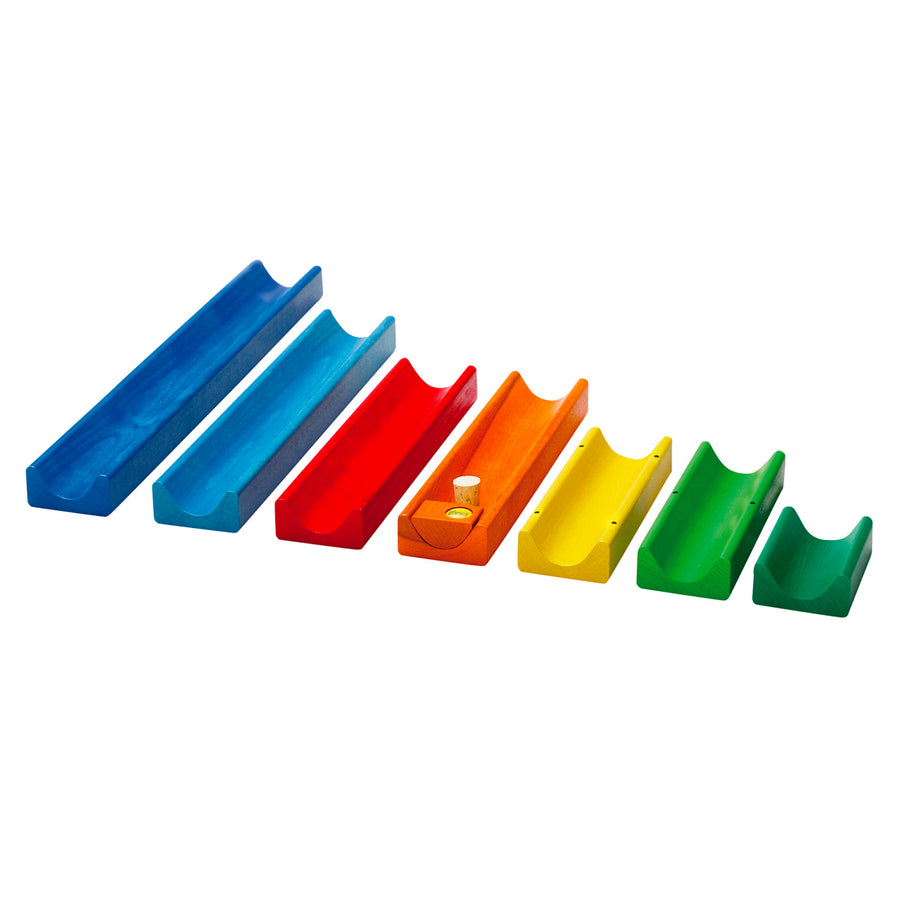 Rainbow pieces of the Erzi wooden marble run set lined up on a white background