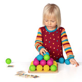 Erzi wooden multicoloured balls stacking game on a wooden base played with a child