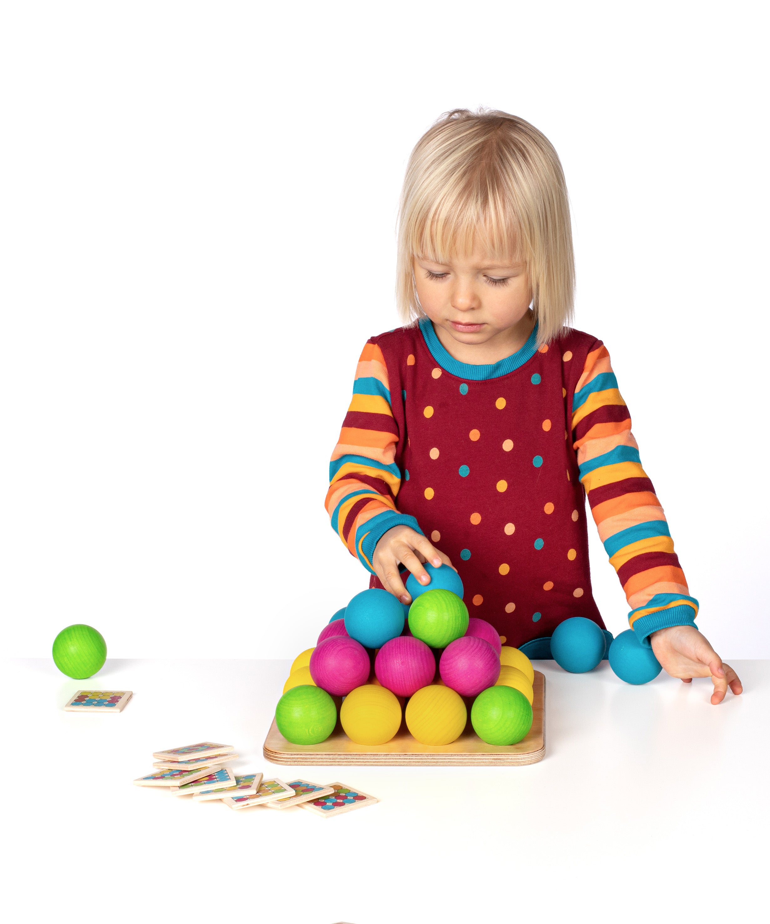 Erzi wooden multicoloured balls stacking game on a wooden base played with a child