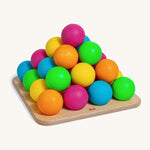 Erzi wooden multicoloured balls stacking game on a wooden base on a cream background.