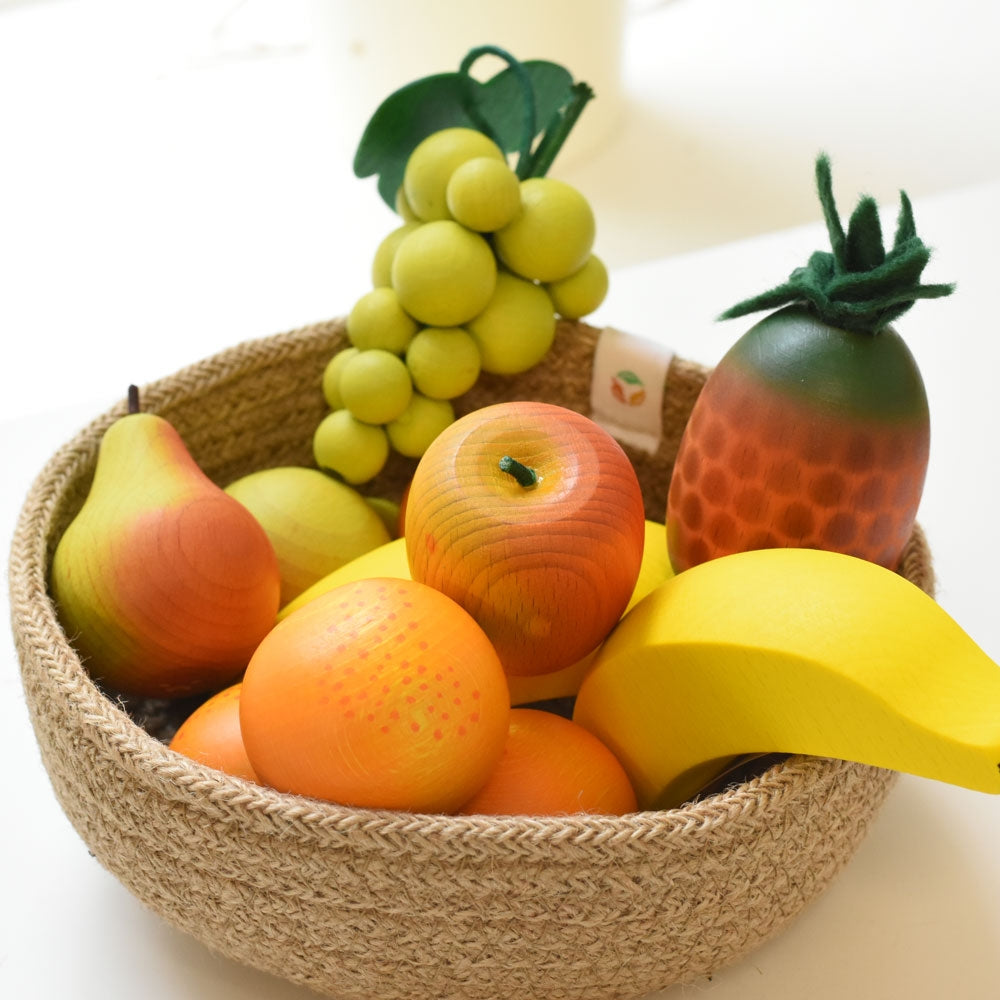 Erzi Banana Wooden Play Food in a Respiin bowl of mixed wooden fruit toys.