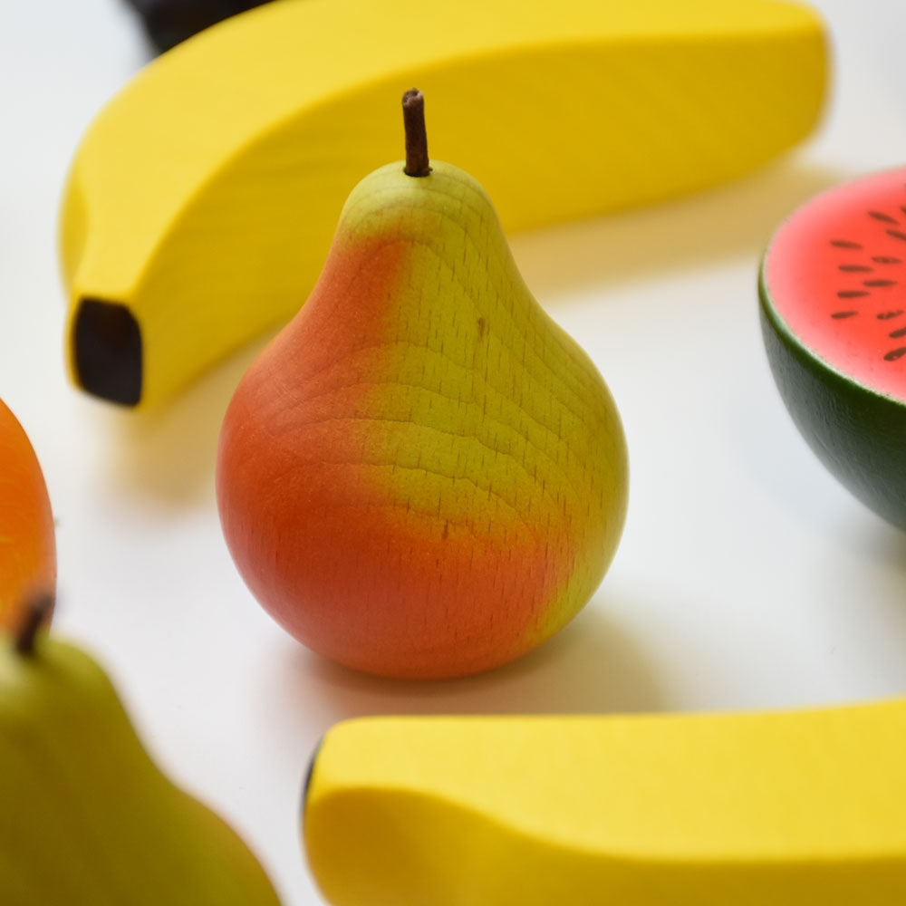 Erzi Green & Red Pear Wooden Play Food with a wooden banana and melon in the background.