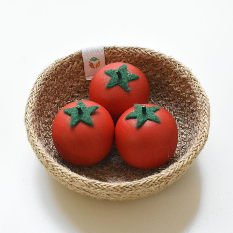 Three Erzi Tomato Wooden Play Food in a natural woven basket