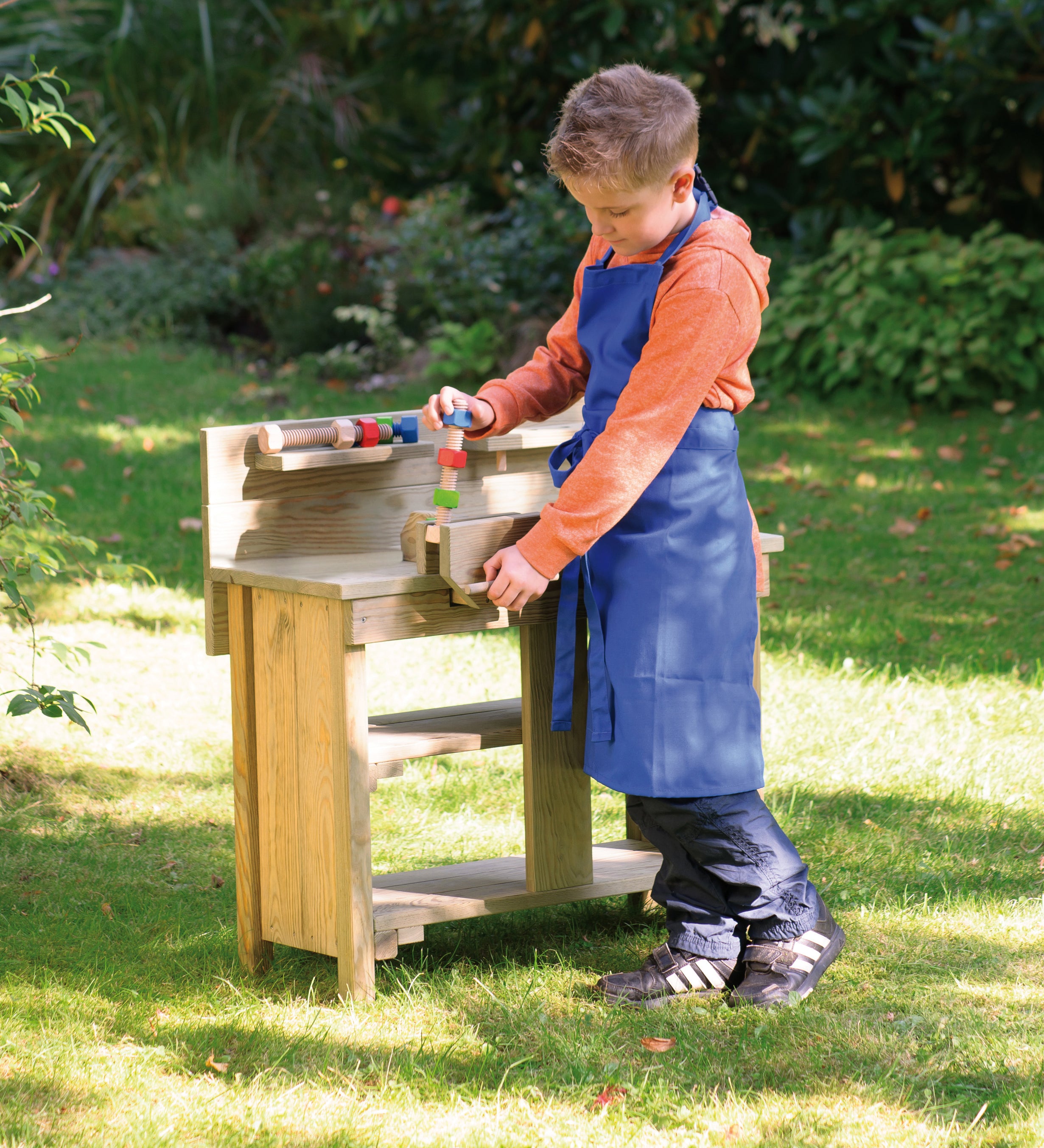 A child pretending to build things with the Erzi wooden toy workbench, outside on a sunny day.