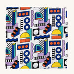 A Etta Loves x Camille Walala XL Muslin Square in shapes design folded up into a square on a plain background. 