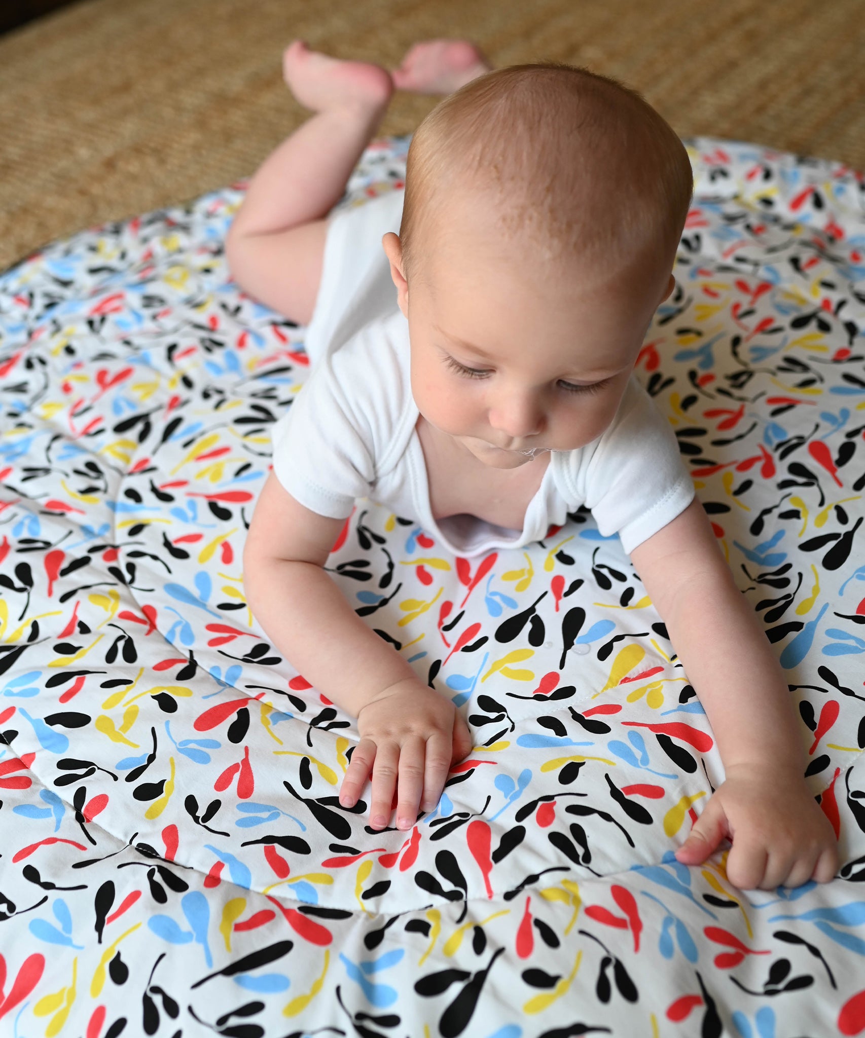 A closer look at the colourful Sycamore print on the Etta Loves Reversible Organic Cotton Baby Play Mat - Plant Print with black and white Ferns on the other side