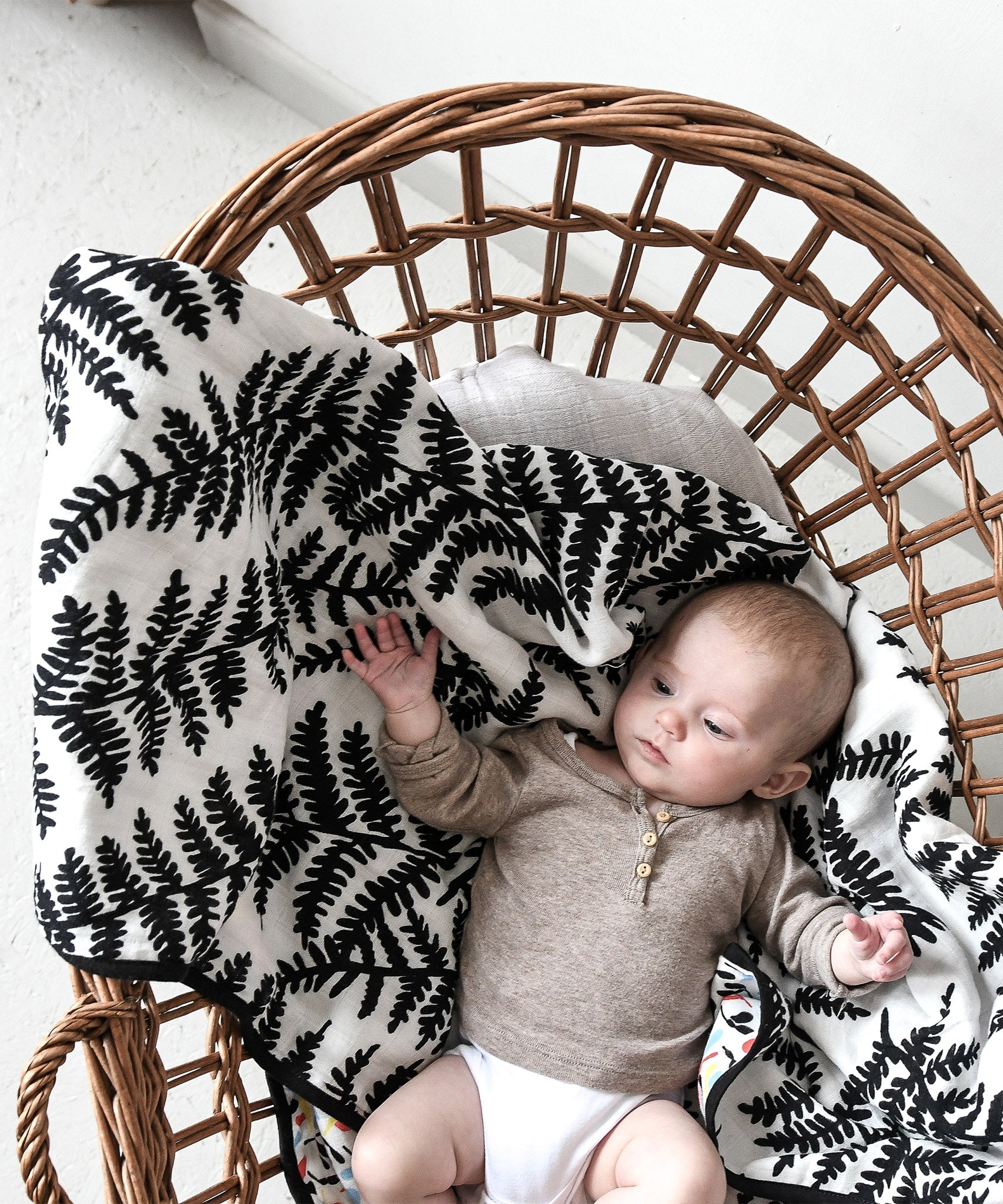  draped over the side of a baby bassinet 