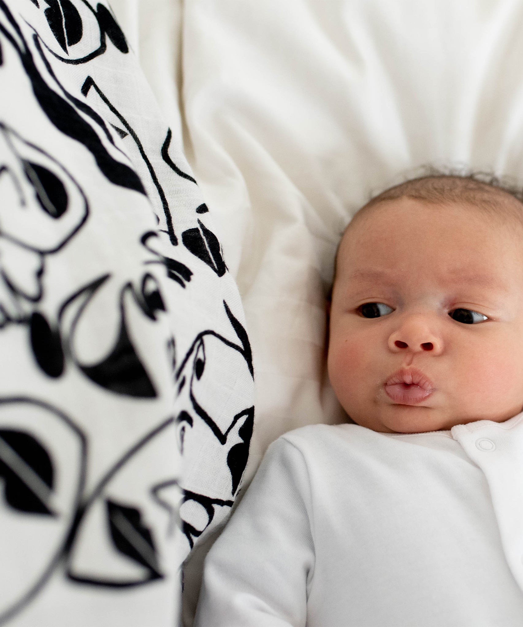 A baby looking up at the Lines print from the Etta Loves Organic Cotton Baby Muslin Squares 3 Pack - Drawing Print