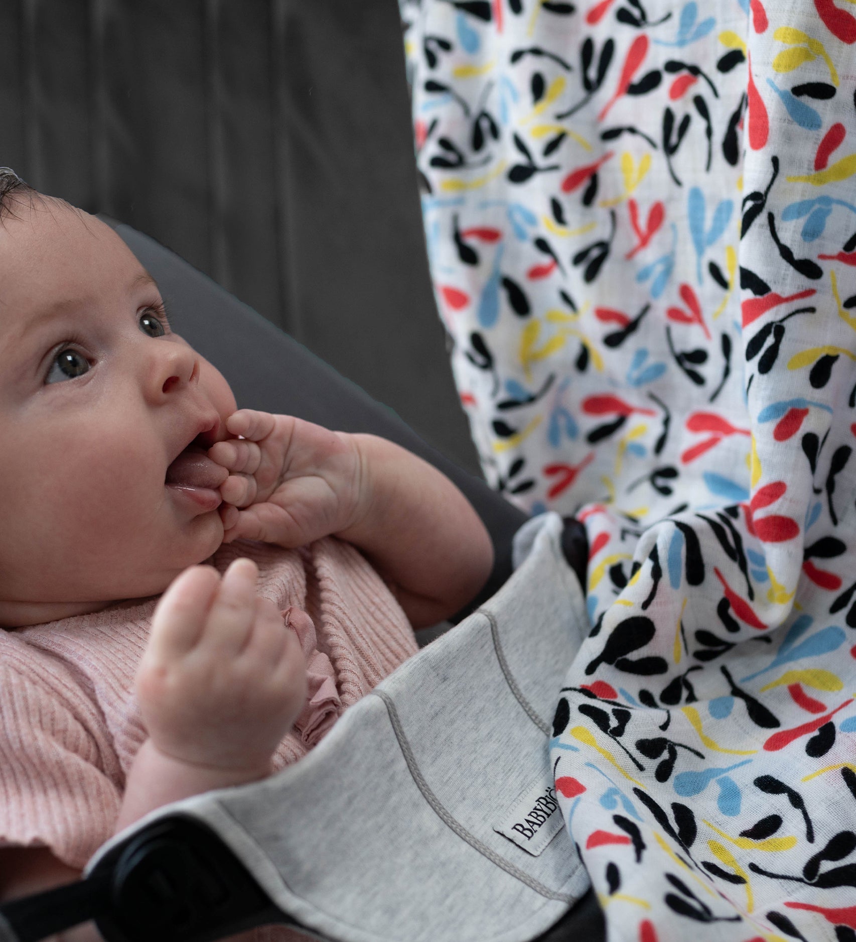 A baby looking up at the colourful Sycamore print on the Etta Loves Organic Cotton Baby Muslin Squares 2 Pack - Fern/Sycamore