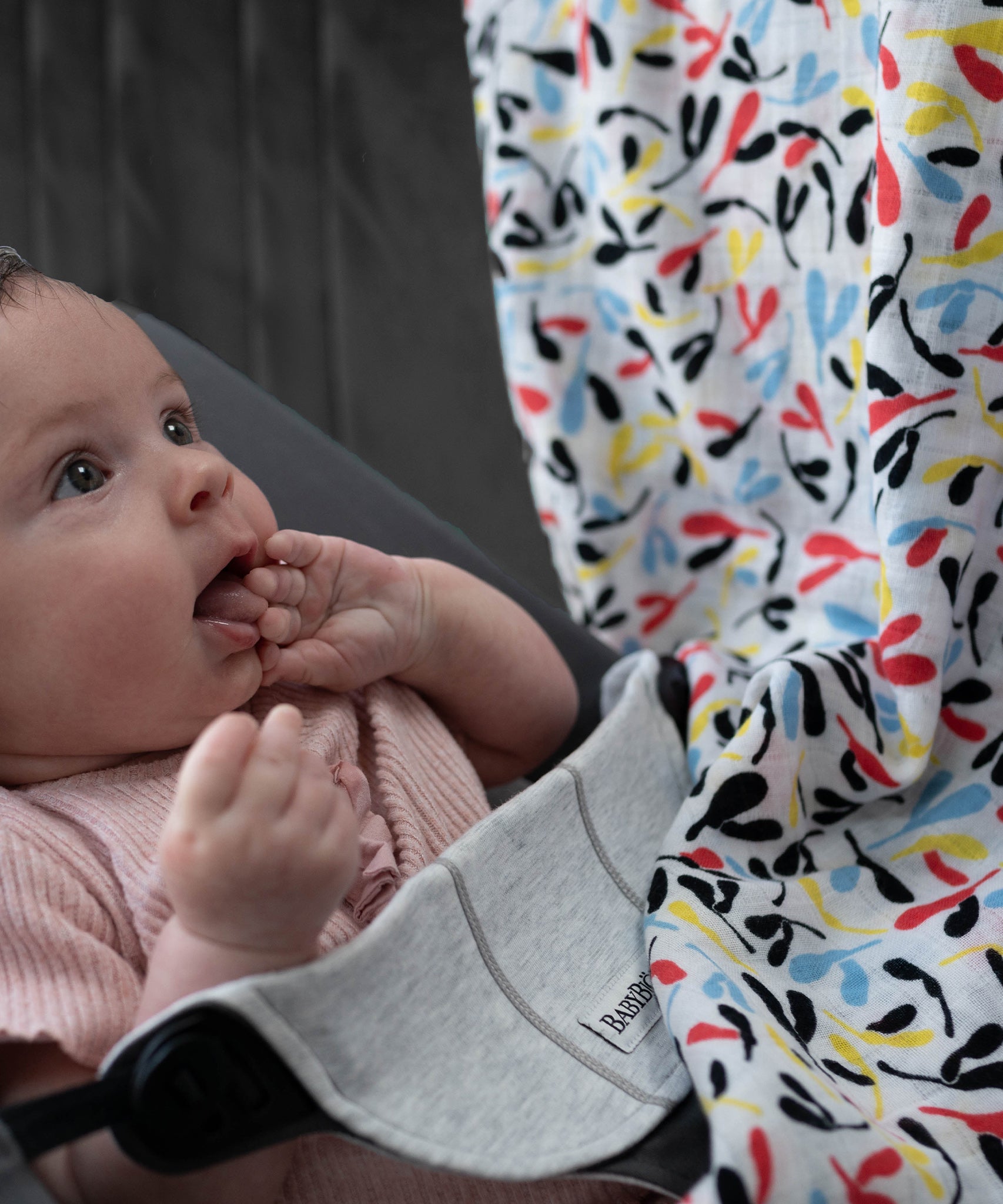 A baby looking up at the colourful Sycamore print on the Etta Loves Organic Cotton Baby Muslin Squares 2 Pack - Fern/Sycamore