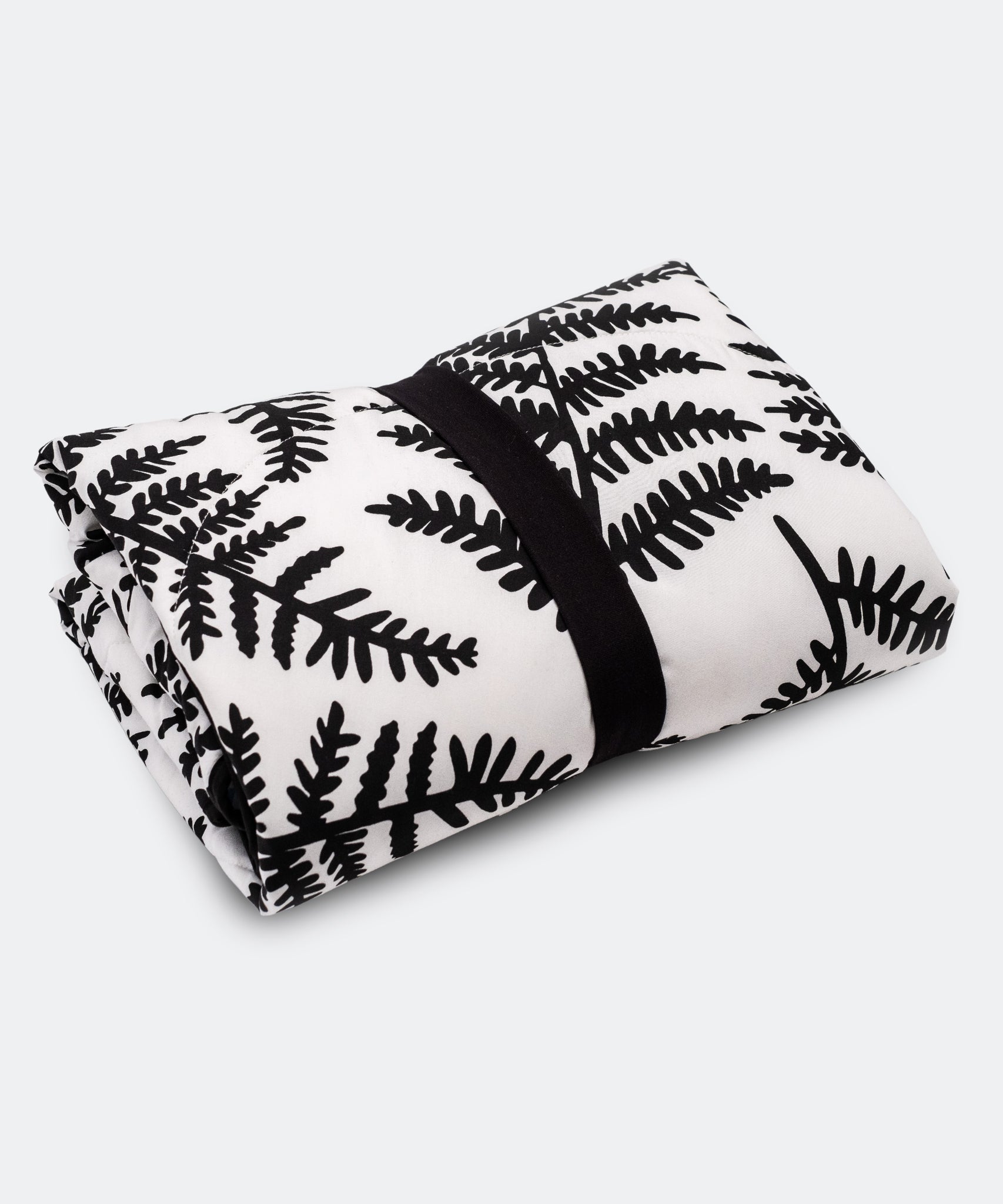 A baby looking and enjoying and looking at the black and white Fern side of the Etta Loves Reversible Organic Cotton Baby Play Mat - Plant Print 