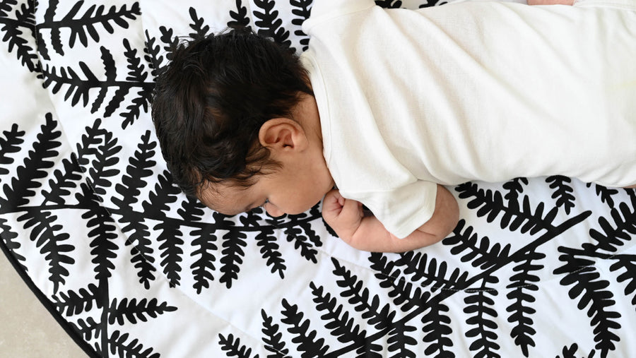 A baby crawling on an Etta Loves playmat