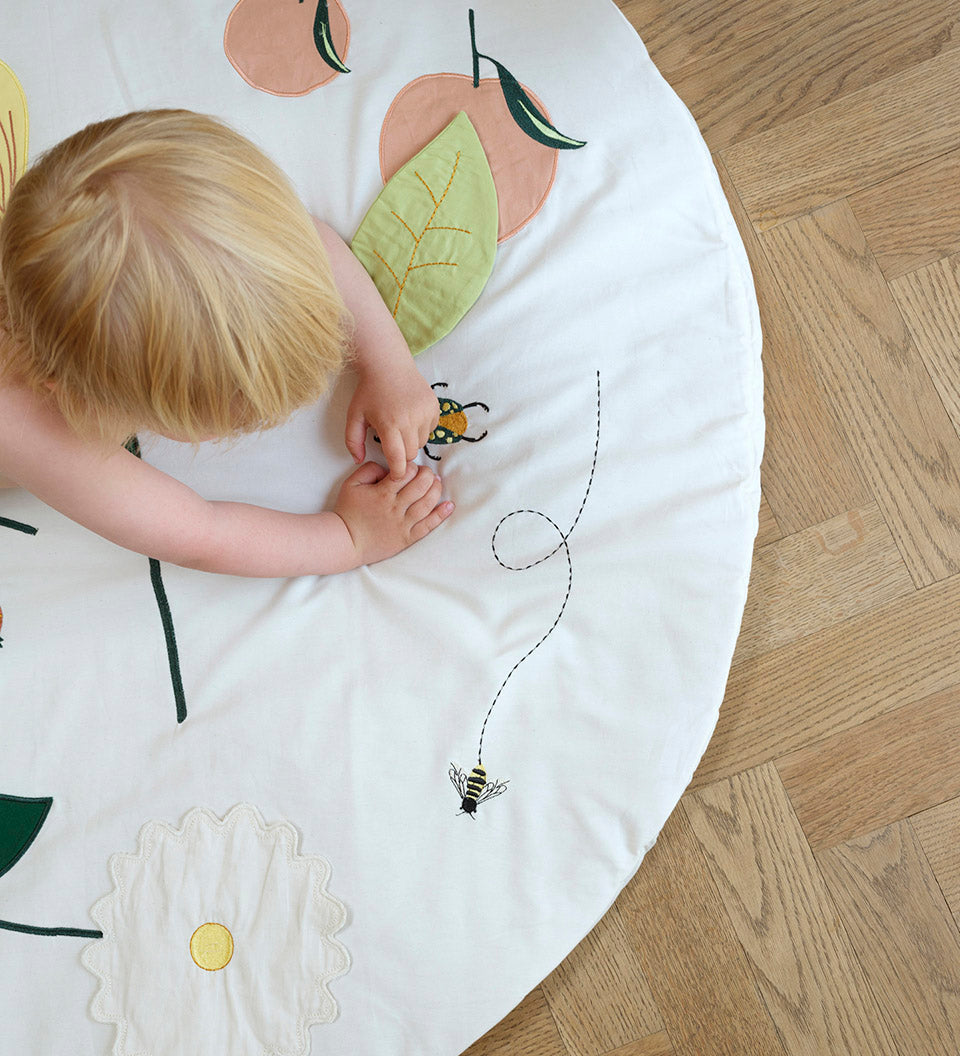 Fabelab activity blanket flower showing child playing and stitching details