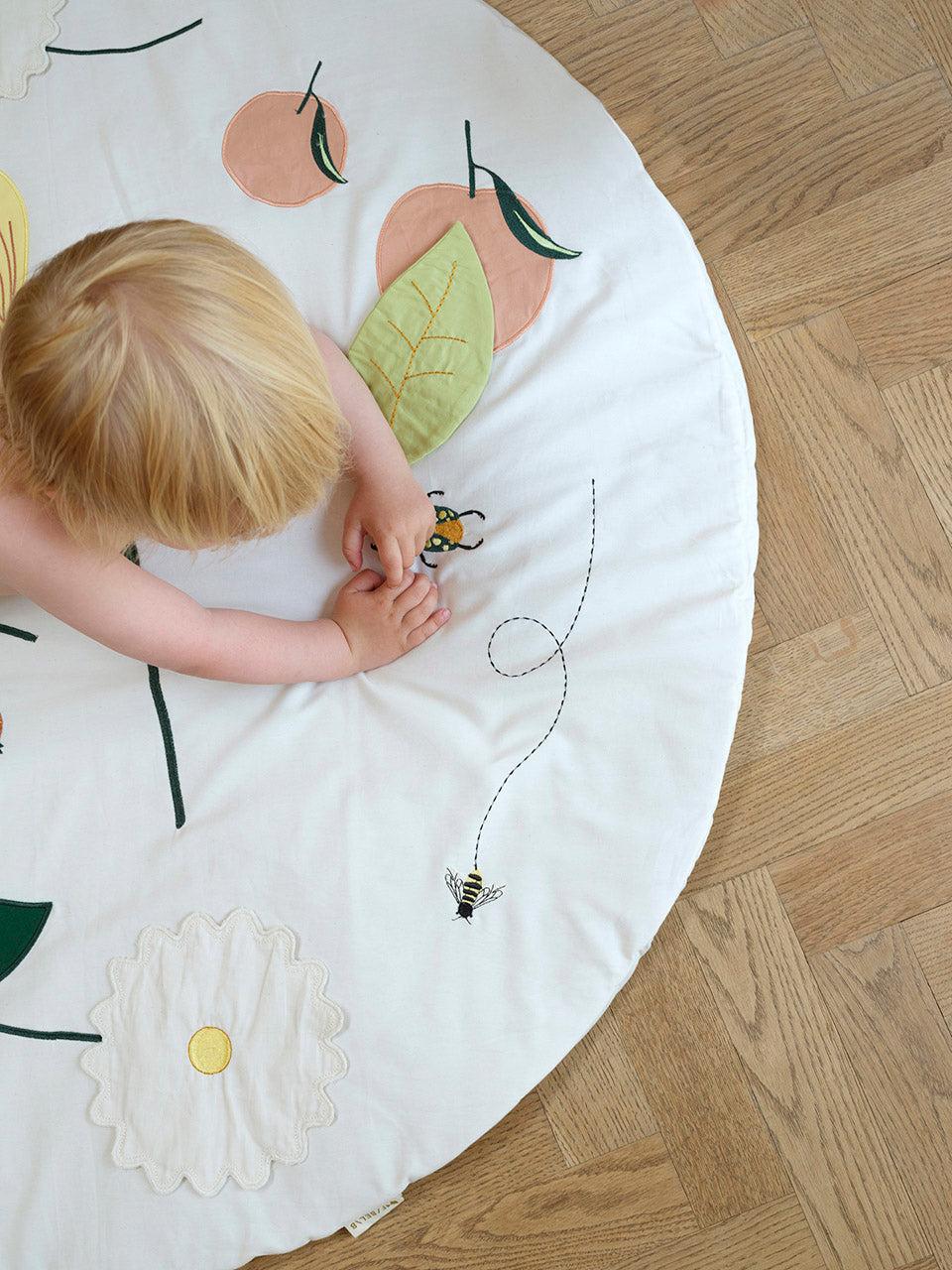 Fabelab activity blanket flower showing child playing and stitching details