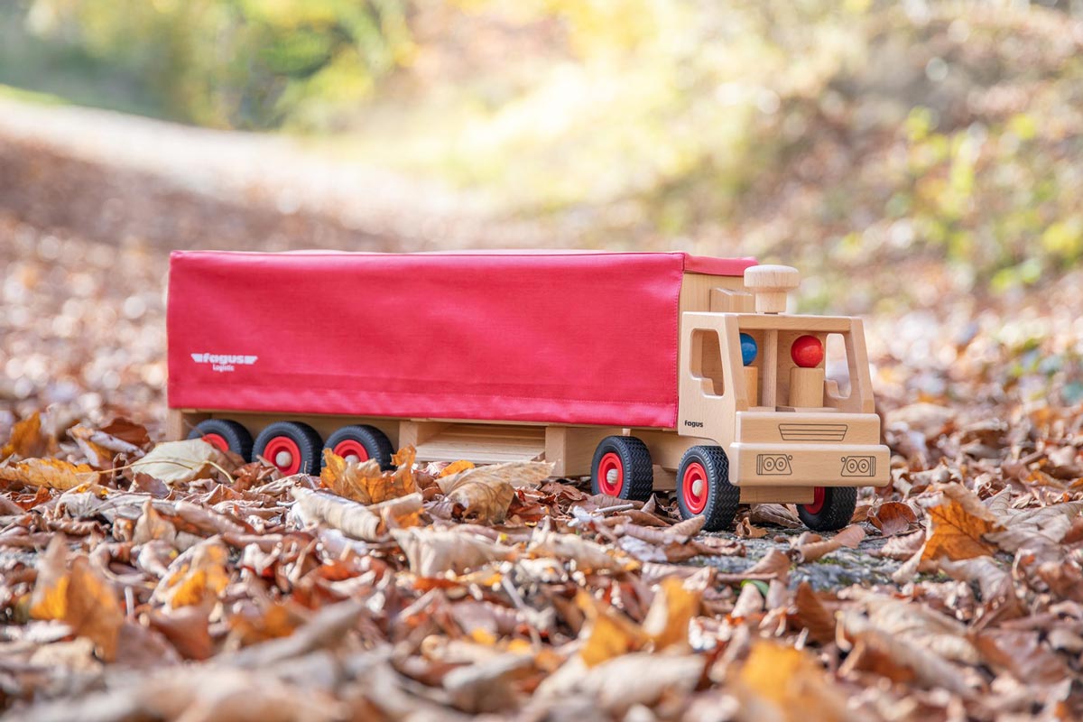 Fagus handmade wooden semi lorry on some brown autumn leaves