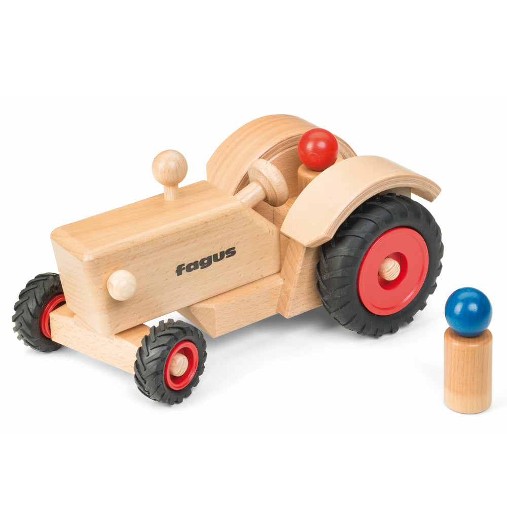 Fagus handmade wooden classic tractor toy on a white background next to a natural wooden peg doll