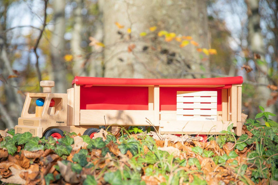 Close up of the Fagus semi truck on some fallen leaves with its trailer open showing off the pallet inside