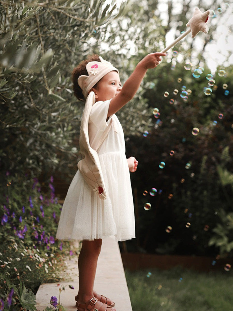 A close up image of a child wearing the Flower Fairy dress up set. The image shows the adjustable crown and wings from the back