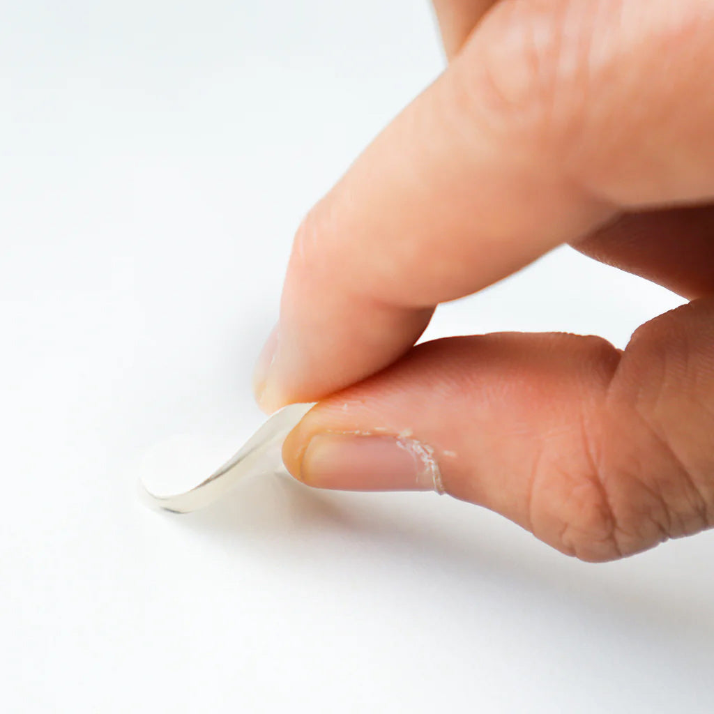 person peeling a single fixits dot