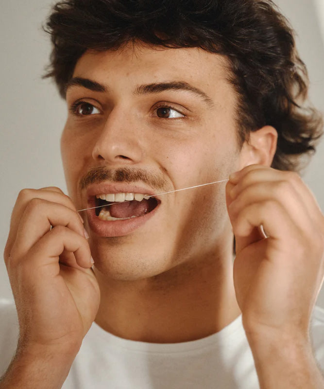 A male flossing his teeth with the Georganics dental floss