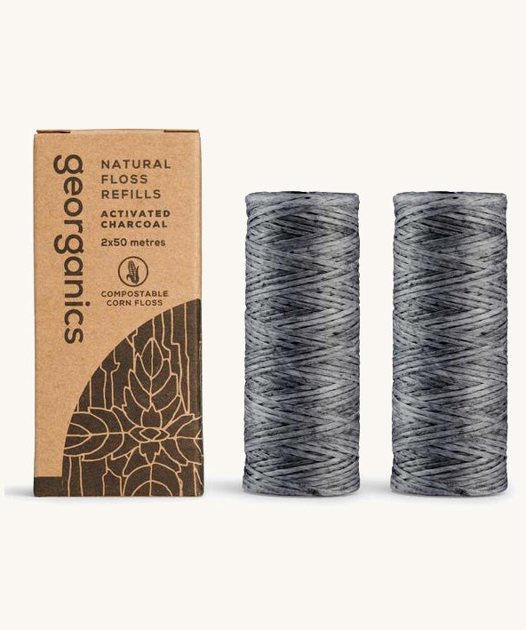 A pair of charcoal floss refills on a cream background with the cardboard box