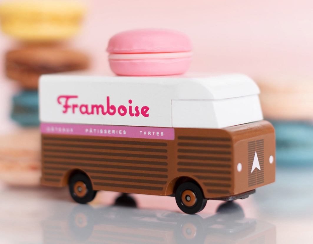 Picture of the Framboise Candylab Candyvan. It is a 1960s style brown and white van with a pink Raspberry Macaron on the roof.