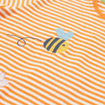 Close up of the Frugi kids lifeboat stripe veg t-shirt. Showing the bee applique with grey wings on orange and white stripe organic cotton fabric