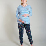 Pregnant woman stood in the Frugi eco-friendly cobalt breton meg maternity pyjama shirt on a grey background