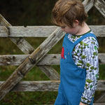 A close up of the side of a child wearing the blue Frugi Babipur cord dungarees.