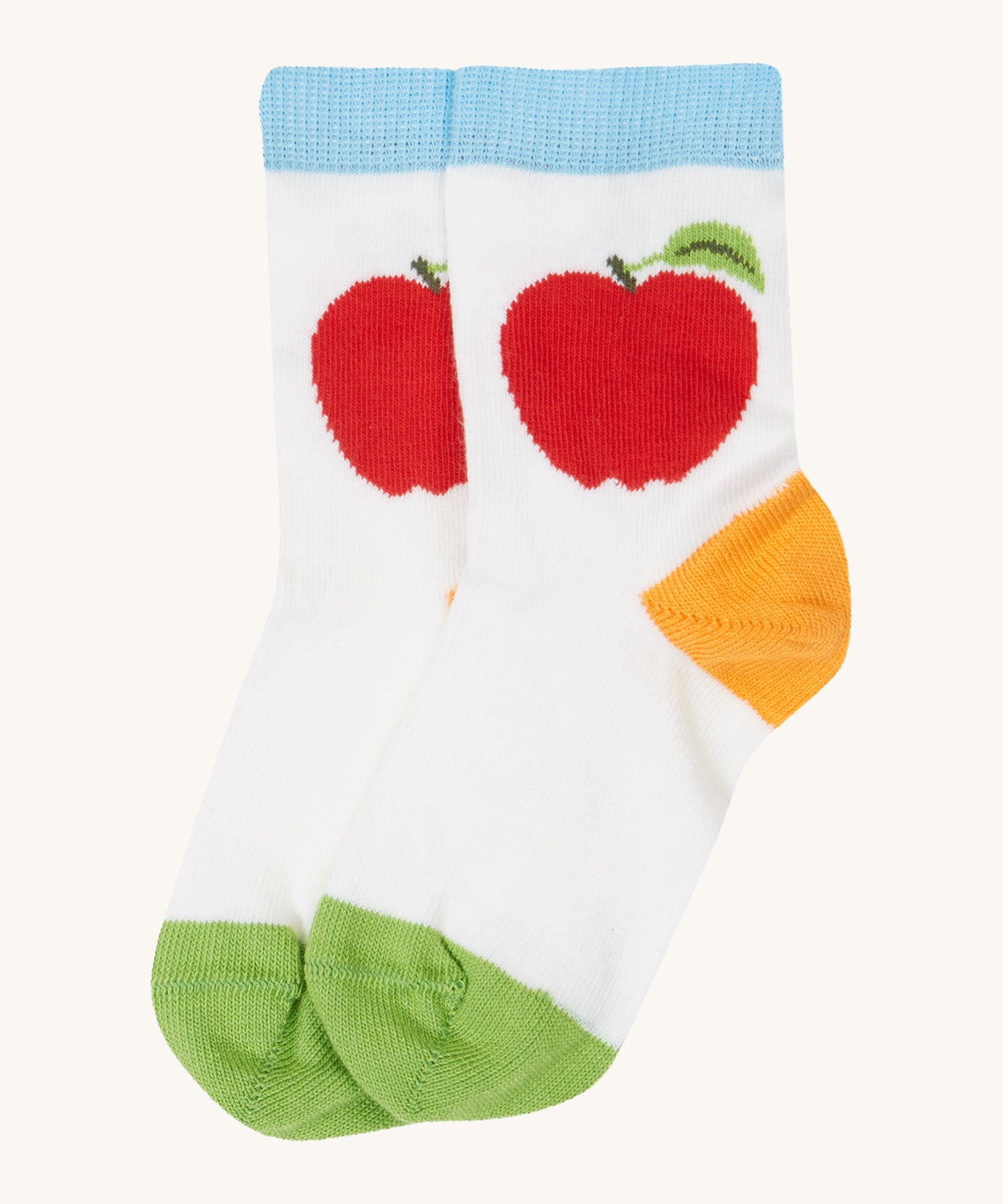 Close up of the baby farm field sock. Showing the apple print and light blue  elasticated cuff with orange heel and green toe contrast panel on white organic cotton fabric. 