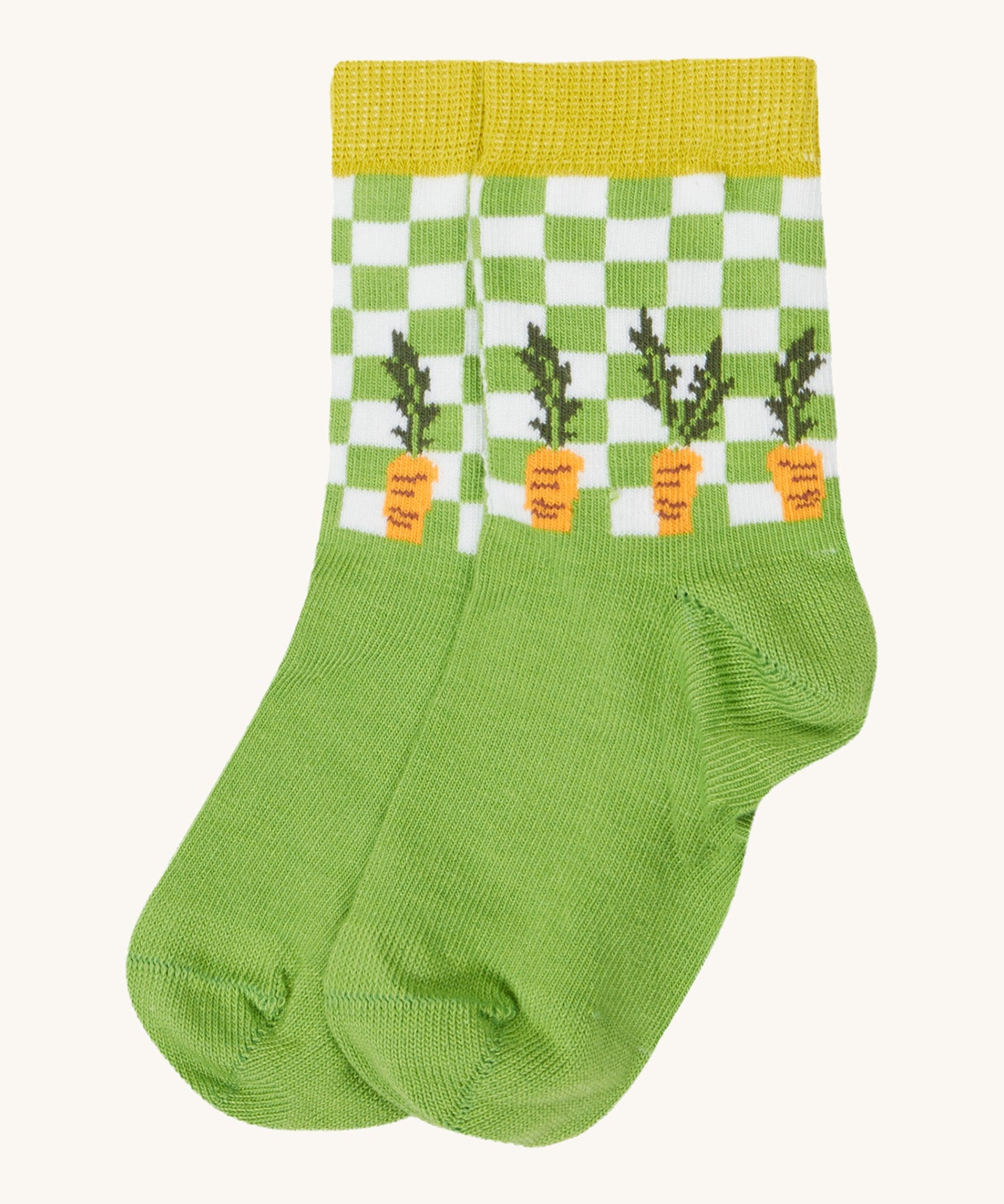 Close up of the baby farm field sock. Showing the carrot print on green check design and mustard yellow elasticated cuff on green organic cotton fabric. 