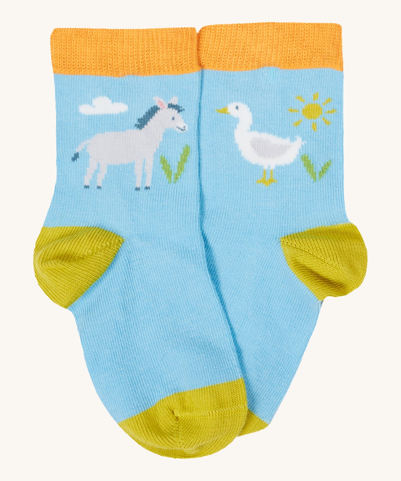 Close up of the baby farm field sock. Showing the grey donkey and white goose print and a light orange elasticated cuff  mustard heel and toe contrast panel on light blue organic cotton fabric. 