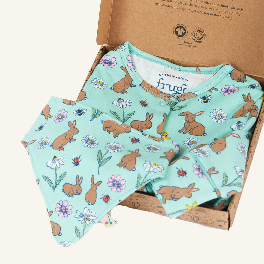 Frugi Organic Cotton Baby Gift Set - Riverine Rabbits. Made with GOTS Organic cotton, the set includes an all-in-one baby grow and a bib in a beautiful mint green fabric and bunny, flower, bee and ladybird print, on a cream background.