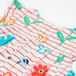 Close up of the Frugi baby Lula paint a floral playsuit. Showing the back popper fastener detail on white and red check organic cotton fabric.