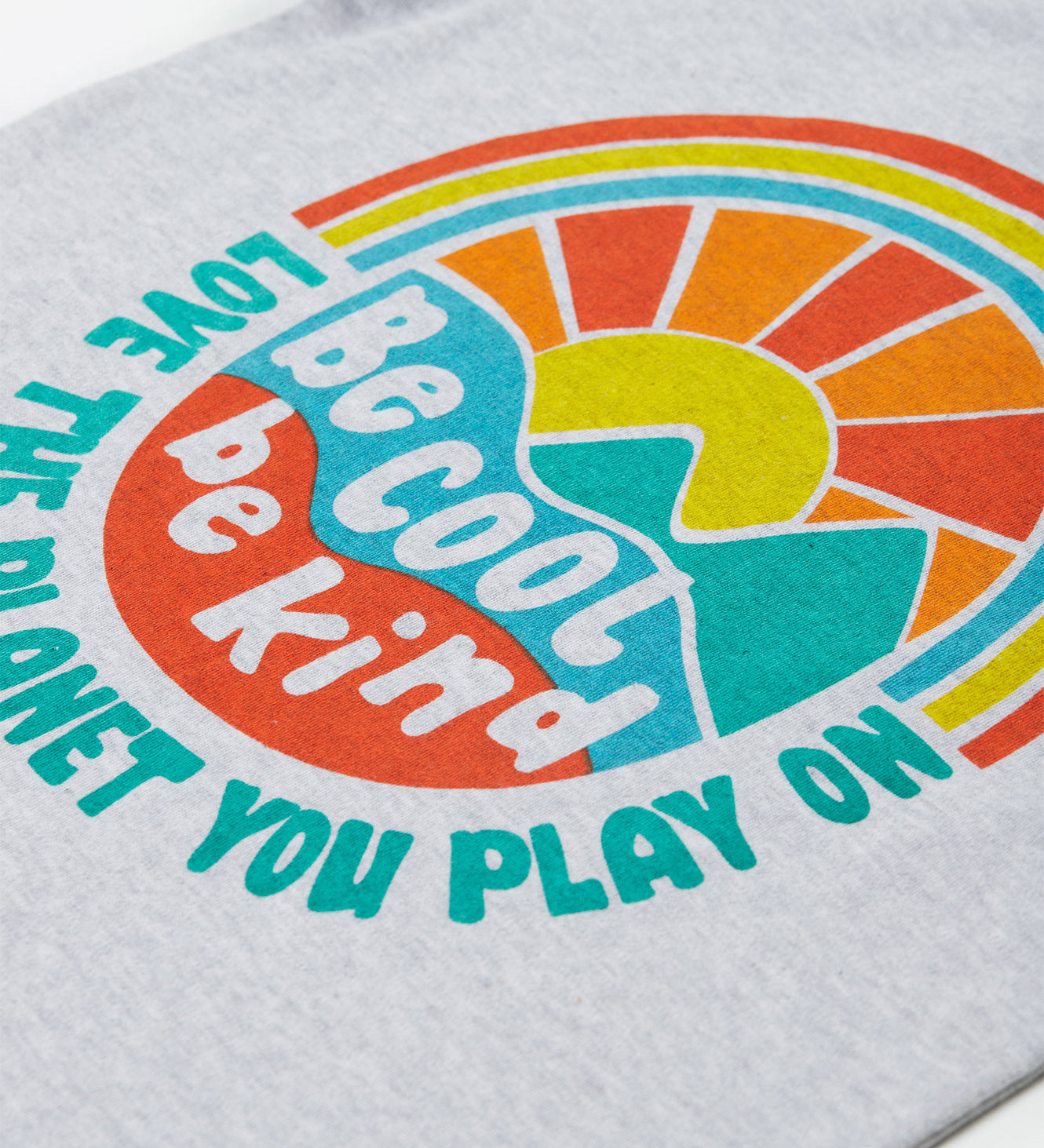 Close up of the Frugi kids be cool carsen printed t-shirt. Showing the vibrant outdoor graphic print with 'Be cool be kind' slogan on top of the graphic on grey organic cotton fabric