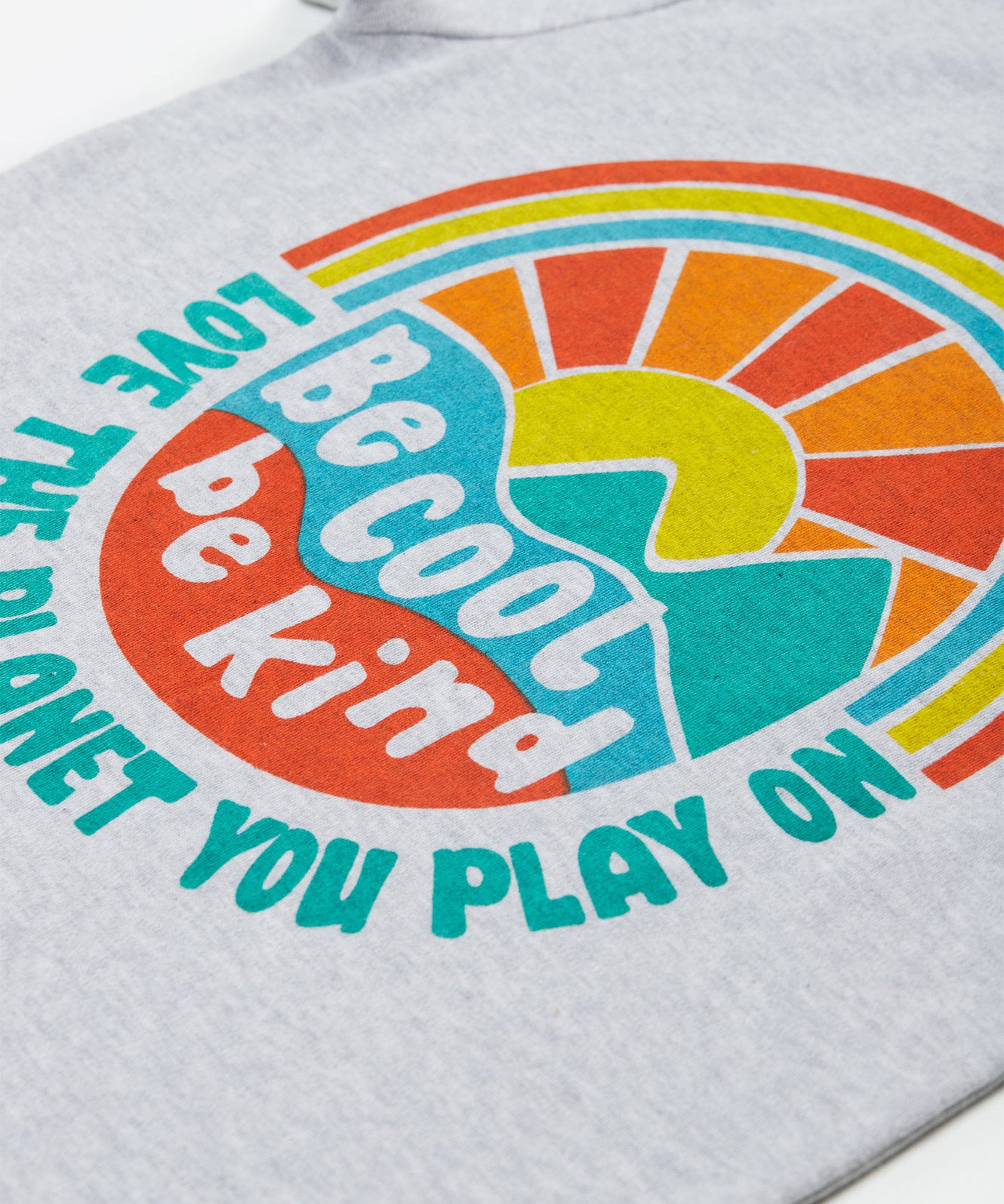 Close up of the Frugi kids be cool carsen printed t-shirt. Showing the vibrant outdoor graphic print with 'Be cool be kind' slogan on top of the graphic on grey organic cotton fabric