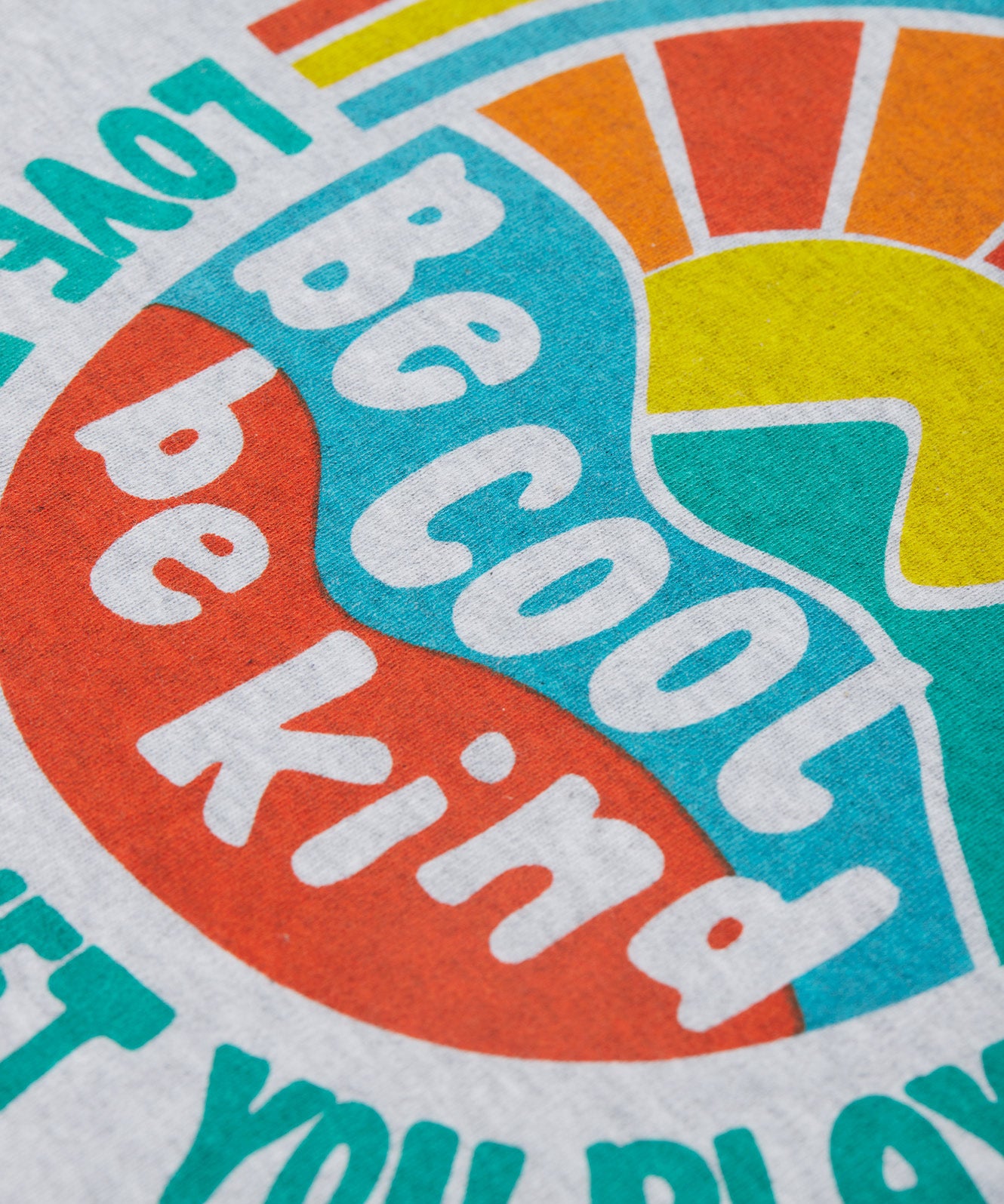 Close up of the Frugi kids be cool carsen printed t-shirt. Showing the vibrant outdoor graphic print with 'Be cool be kind' slogan on top of the graphic on grey organic cotton fabric