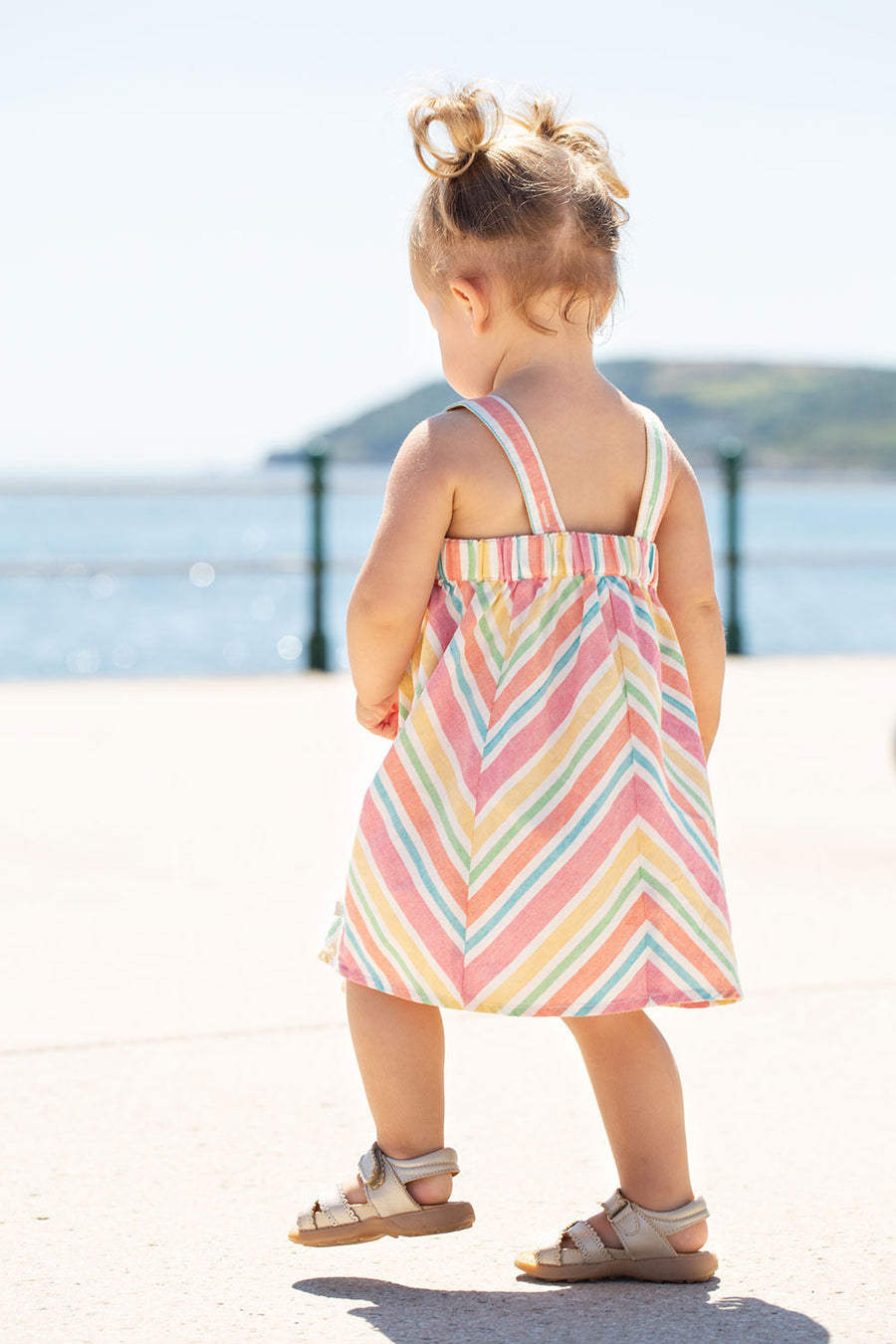 Child wearing the Frugi Stripe dress Beach Party Dress showing the back of the dress