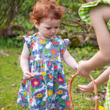 A child wearing a Frugi Baby Bella Organic Cotton Dress with a Bunny Bounce print design.