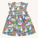 Frugi kids Bella dress bunny bounce - GOTS organic cotton kids sleeveless dress  with slight shoulder hem. Features a collection of white rabbits printed on a light blue organic cotton fabric with different coloured flowers and bright rainbows. 