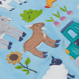 A close up of the Frugi kids bluebird farm life t-shirt  showing the cow, donkey, hen, goat, sheep, goose, tractor, sunflower, carrot, radish and a beetroot appliqué on light blue organic cotton fabric. 