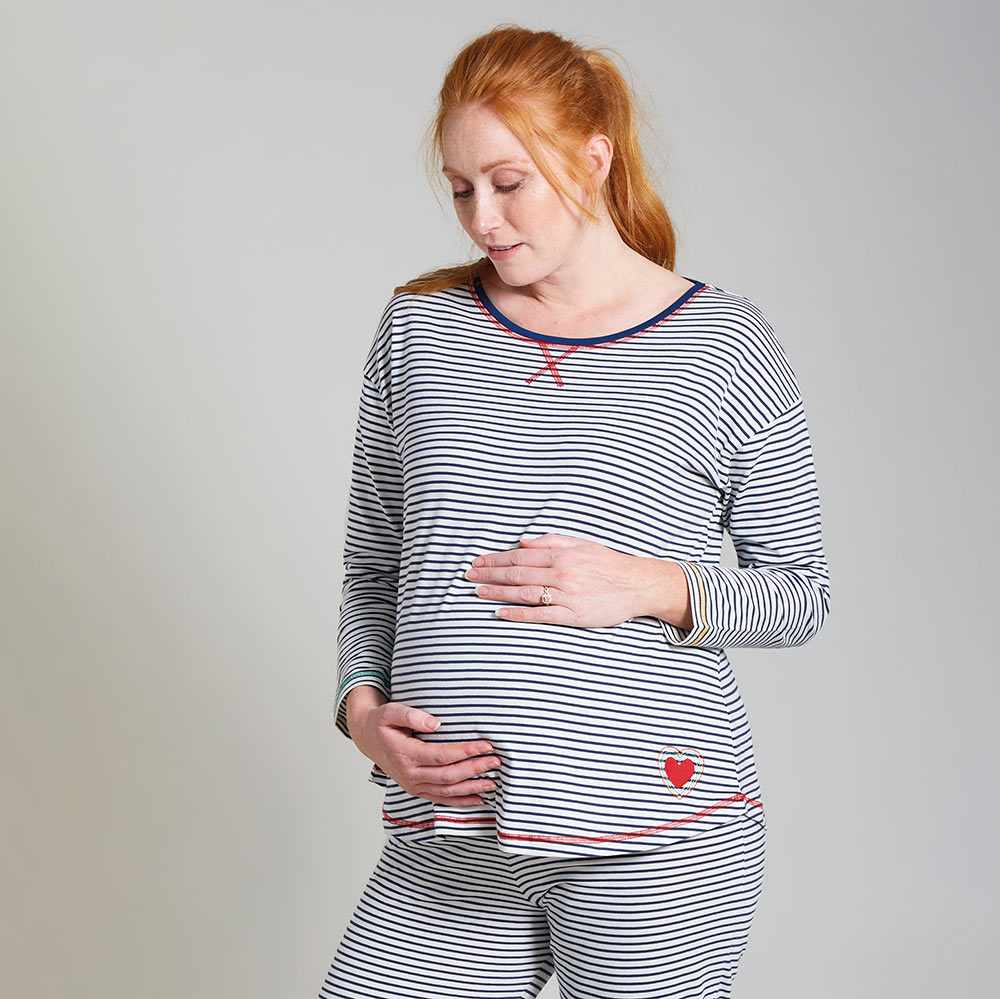 Woman modelling the Frugi long sleeve navy breton striped maternity and nursing pyjama top