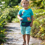 A child wearing the Frugi Canopy Land Sea Penryn Panel T-shirt with Frugi sea moss stripe Sunny Shorts.