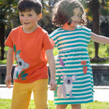 Two children wearing Frugi organic cotton clothing. One is wearing the  Carsen Cool Koala applique t-shirt with yellow bumblebee Samson shorts. The other child is wearing a Koala Felicity Dress.