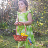 A child wearing the Frugi Children's Organic Cotton Macaw green and white Gingham Zaria Dress.