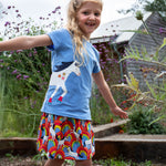 A child wearing the All Over The Rainbow print organic cotton skort with a cornflower blue horse applique t-shirt..